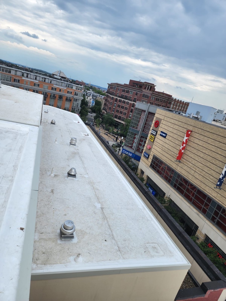 Large completed white reflective membrane roof with the city skyline behind it