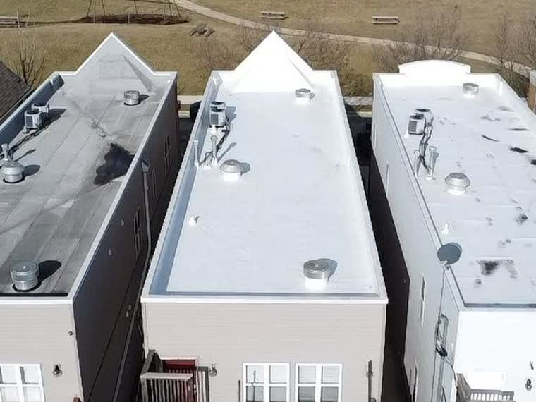 Completed white roofs on stepped building sections.
