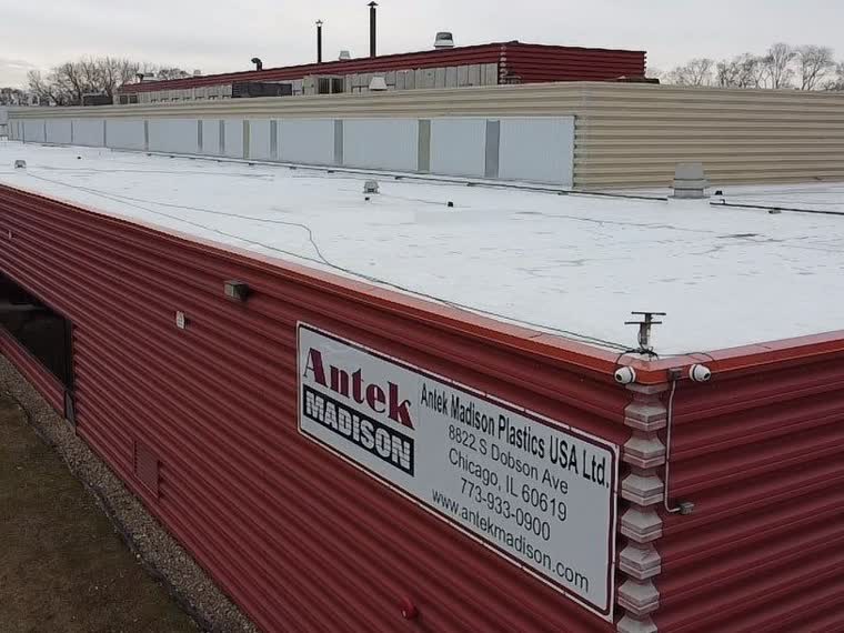 Metal roof over a commercial building, low-slope section at the rear.