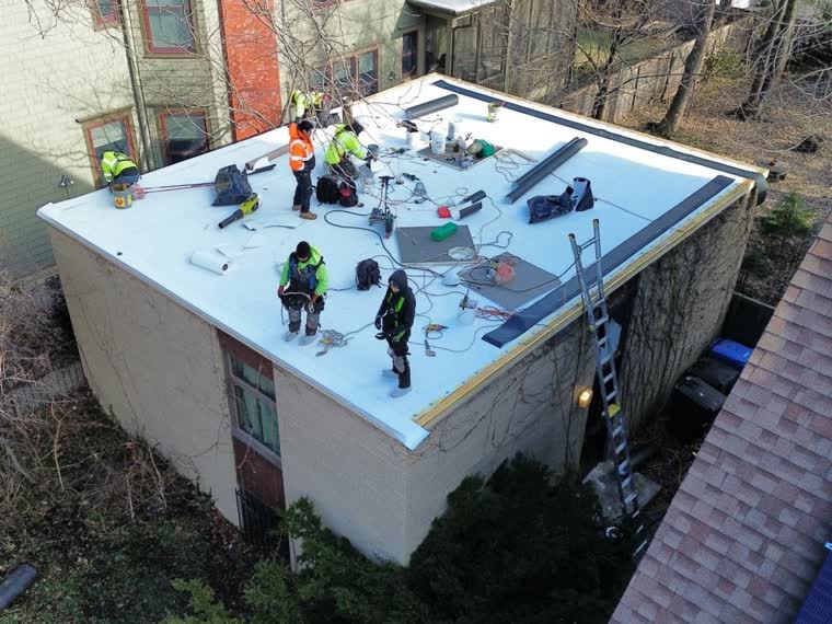 Crew working a small commercial roof in winter conditions.