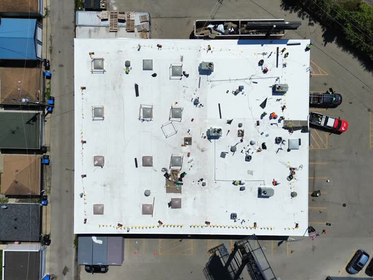 Large reflective roof with dense rooftop mechanical equipment, urban setting.