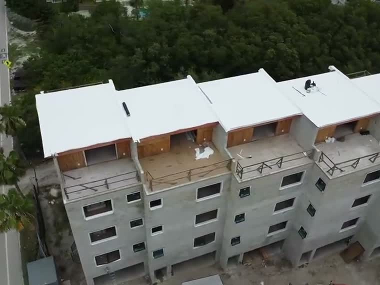 Multifamily building under construction, roof deck exposed.