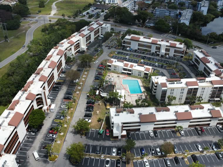 Wide aerial of a multi-building community with completed roofs throughout.
