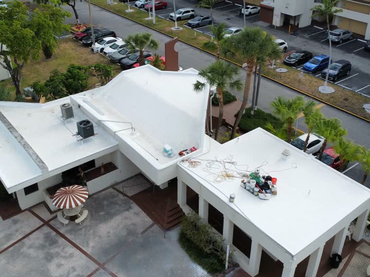 White membrane over a stepped commercial building with a curved entry canopy.