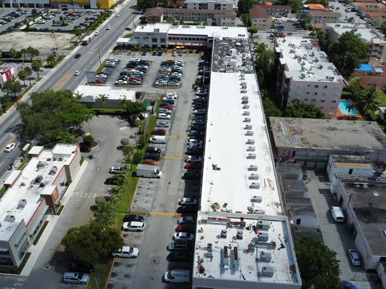 Aerial down a retail corridor — reflective roofs the length of the centre.