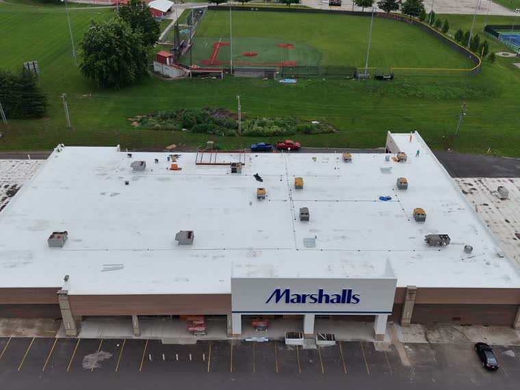 Big-box retail roof, reflective membrane across the full span.