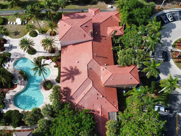 Hospitality property with barrel tile roofs surrounding a pool deck.