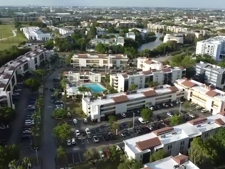 Aerial along a dense low-rise commercial corridor.