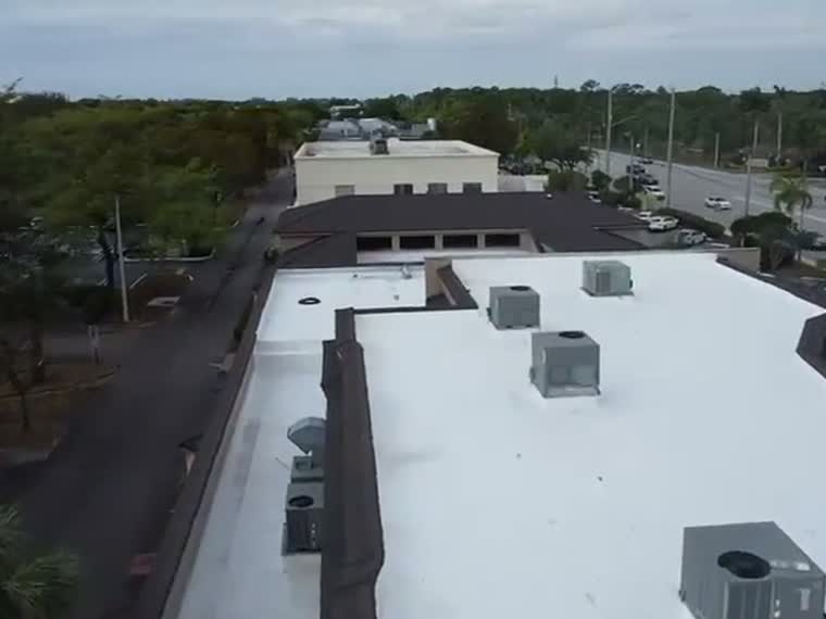Completed reflective roof on a low commercial building.