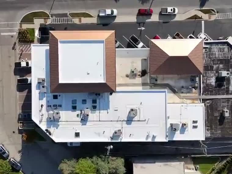 White membrane and tile sections on a mixed-height building.
