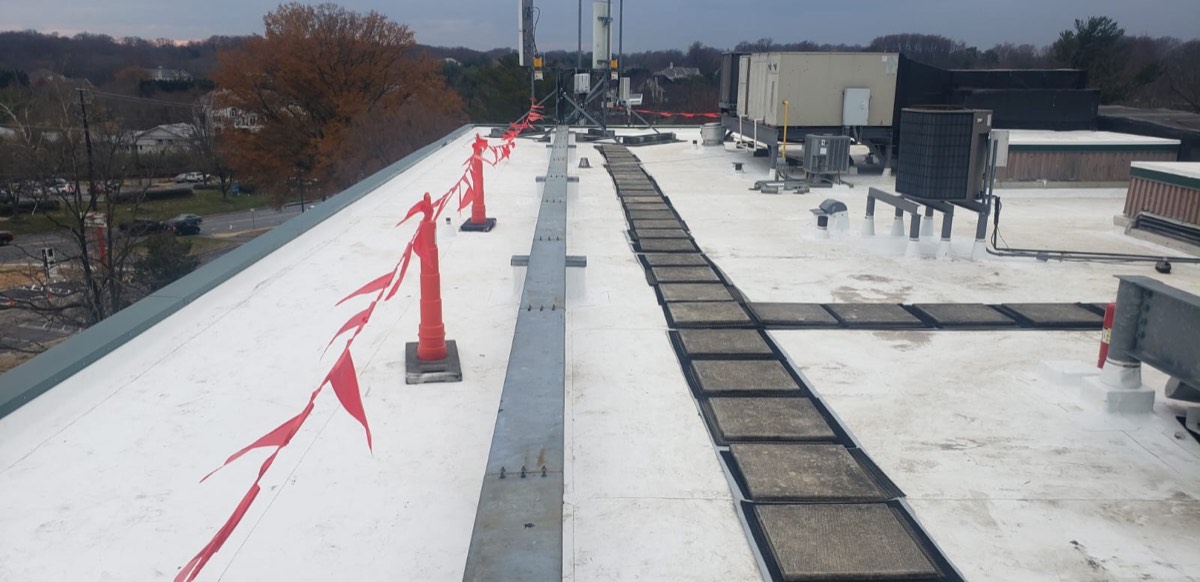 Roof walkway pads and marked safety perimeter on a commercial roof